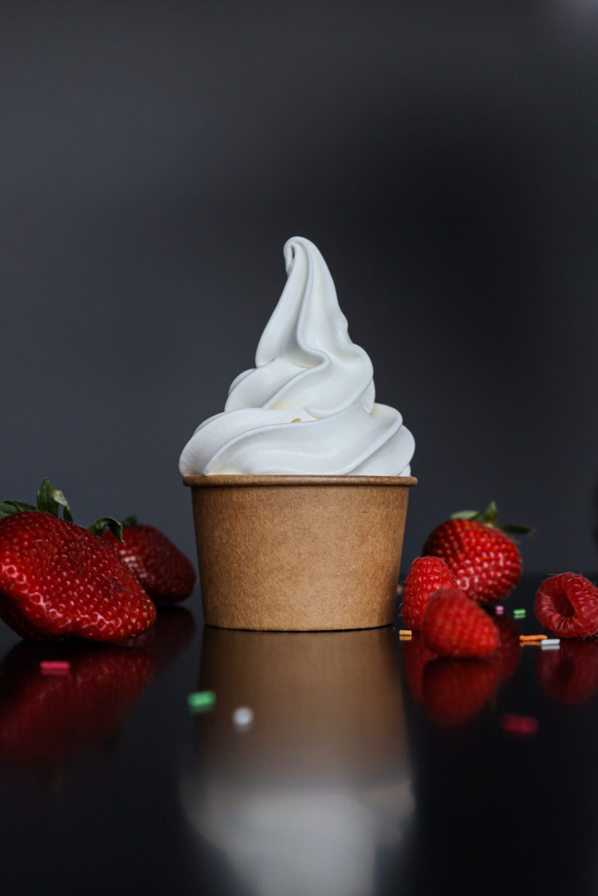 Revala soft serve in kraft cup with fresh strawberries and raspberries